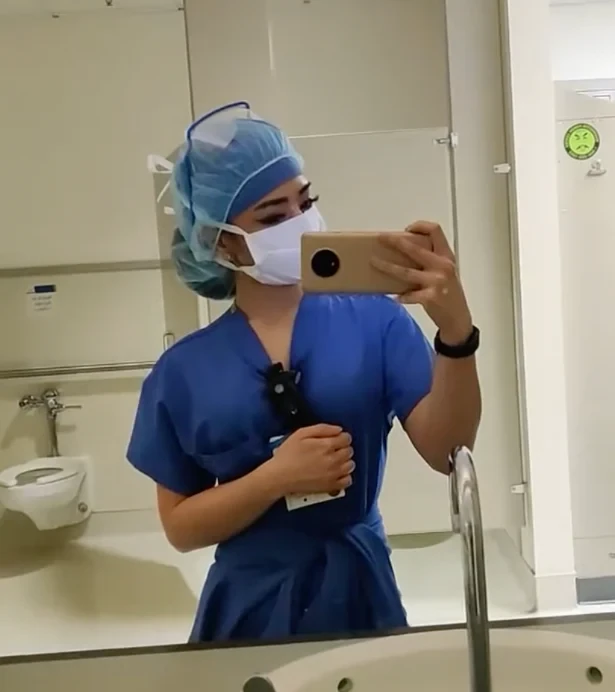 Tawny as a nurse in scrubs, mirror selfie from her nursing days